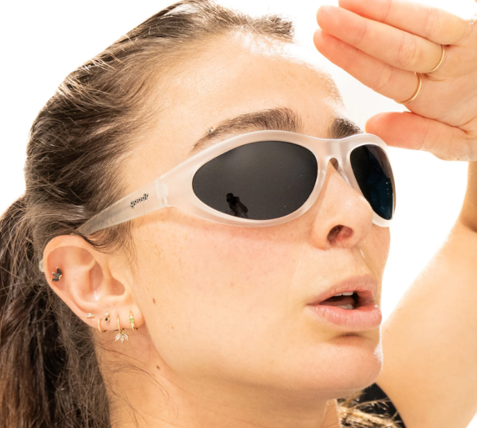 Woman wearing goodr BugG Cleared for Takeoff sunglasses with a transparent no-slip frame and black oval lenses, styled for active wear and high-performance comfort.