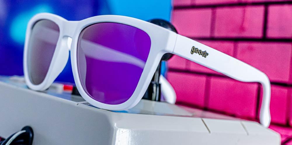 goodr OG running sunglasses Side Scroll Eye Roll model with white frame and purple polarized lenses, no slip no bounce fit, and all polarized lenses—ideal for running and active lifestyles.