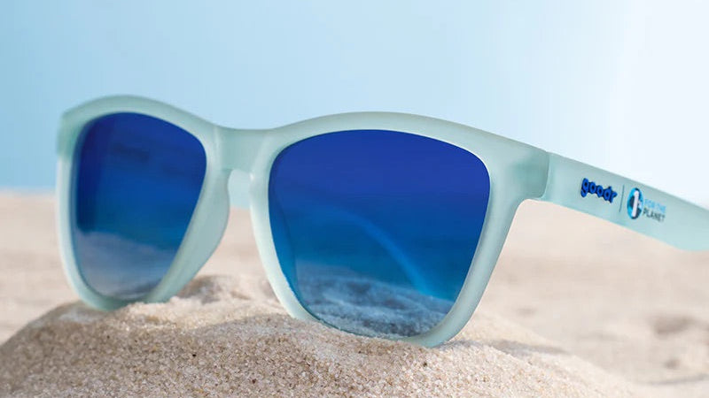 “goodr These Shades Are Still Trash sunglasses with frosted translucent frame and blue mirrored lenses made from recycled materials.”